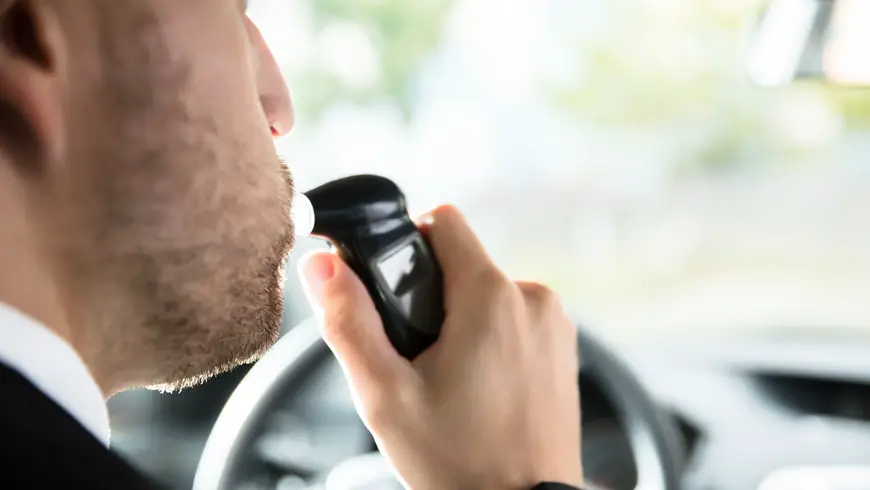 Close-up Of A Man Sitting Inside Car Taking Alcohol Test