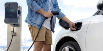 Achat d'un véhicule électrique : 10 points à ne pas négliger. Un homme s’apprête à charger son véhicule