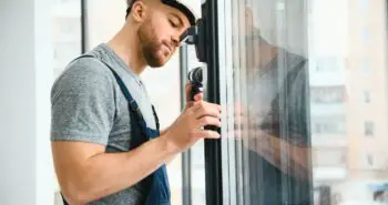 un ouvrier contrôle la fenêtre à triple vitrage