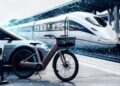 Train futuriste et vélo électrique en gare.
