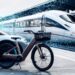 Train futuriste et vélo électrique en gare.