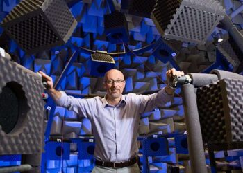Homme dans laboratoire de tests acoustiques, entouré de mousses.