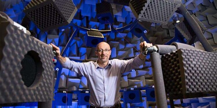 Homme dans laboratoire de tests acoustiques, entouré de mousses.