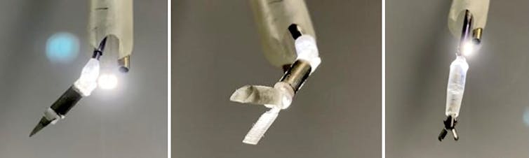 Three small robotic tools, one with a blade and two with grippers.