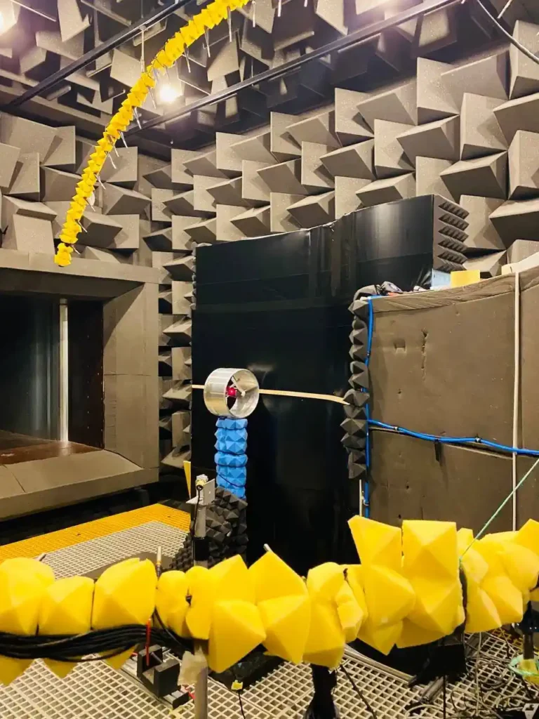 Banc d'essai du ventilateur canalisé BLI à l'intérieur de la chambre anéchoïque de l'Université de Bristol, comprenant un ventilateur canalisé monté sur la plaque S incurvée et un réseau de microphones pour les mesures aéroacoustiques.