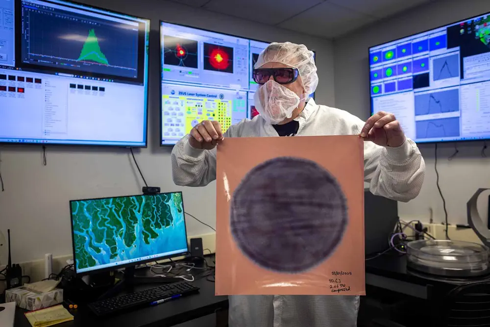 Gregg Sucha, ingénieur laser, montre une marque de brûlure laser sur du papier photographique dans une salle de contrôle du laboratoire ZEUS. Ce test permet de détecter tout point chaud potentiellement dommageable dans l'impulsion laser élargie au moment où elle entre dans le compresseur qui la réduira en une impulsion laser minuscule, intense et puissante. Les lignes proviennent d'imperfections dans le cristal amplificateur final, qui doit être remplacé avant que ZEUS puisse atteindre sa pleine puissance de 3 pétawatts. Avec ses deux pétawatts, ZEUS est désormais le laser le plus puissant des États-Unis.