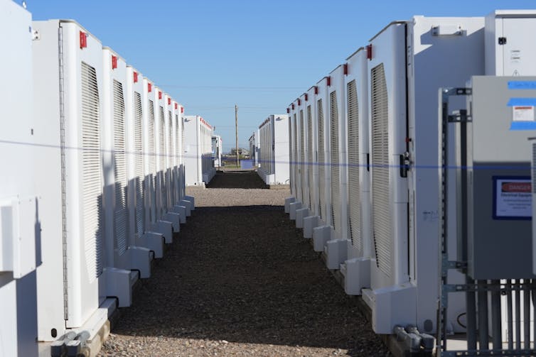 Two parallel rows of large white metal boxes stretch into the distance.