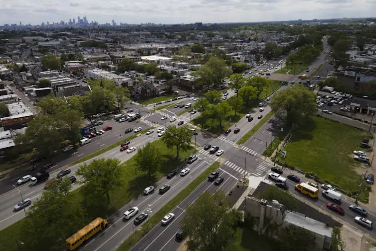 An overhead view of roads intersecting on the outskirts of an urban center.