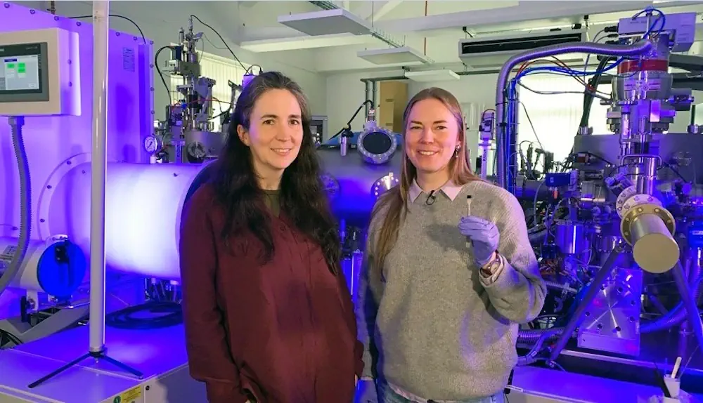 Le professeur Kelly Morrison, à gauche, et le Dr Naëmi Leo, devant le système de nanolithographie de l'université de Loughborough. Le Dr Leo tient la puce sur laquelle figure l'image du "plus petit violon du monde".
