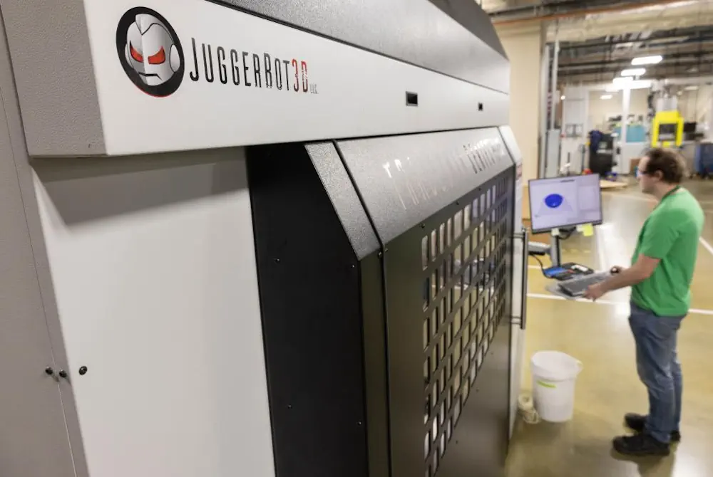 Tyler Smith, membre du personnel technique du Manufacturing Demonstration Facility, fait fonctionner une imprimante 3D Juggerbot au MDF sur le campus Hardin Valley de l'ORNL. Juggerbot collabore avec l'ORNL pour mettre au point des systèmes qui impriment à la fois des polymères thermodurcissables et thermoplastiques