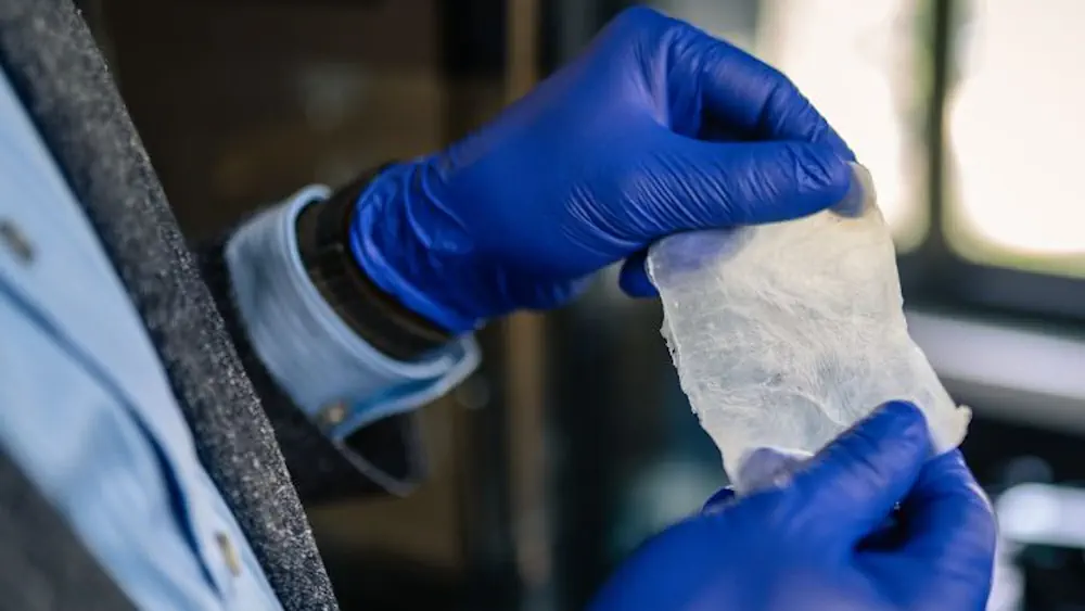 Rahman tient le bioplastique, fabriqué à partir de cellulose bactérienne, qui pourrait remplacer le plastique.