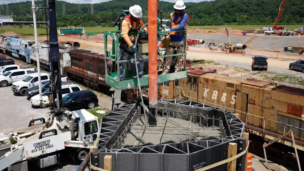 Les ouvriers de Barnard Construction versent du béton dans le coffrage en ABS renforcé de fibres de carbone pour produire l'une des colonnes Janus coulées sur place. 
