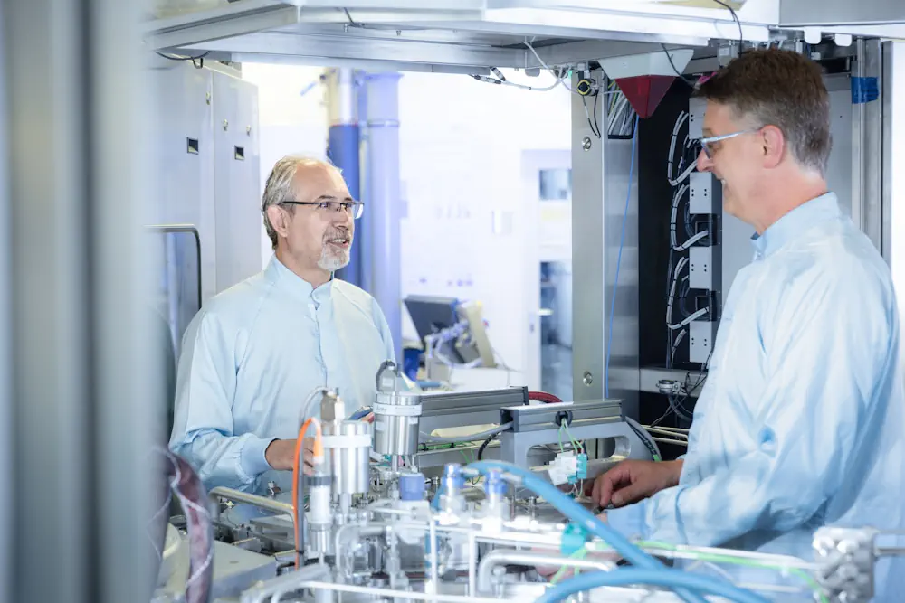 Dr Dan Buca (à gauche) et Andreas Tiedemann (à droite) de l'Institut Peter Grünberg (PGI-9) du centre de recherche de Jülich devant l'installation CVD d'AIXTRON avec laquelle le wafer a été revêtu.