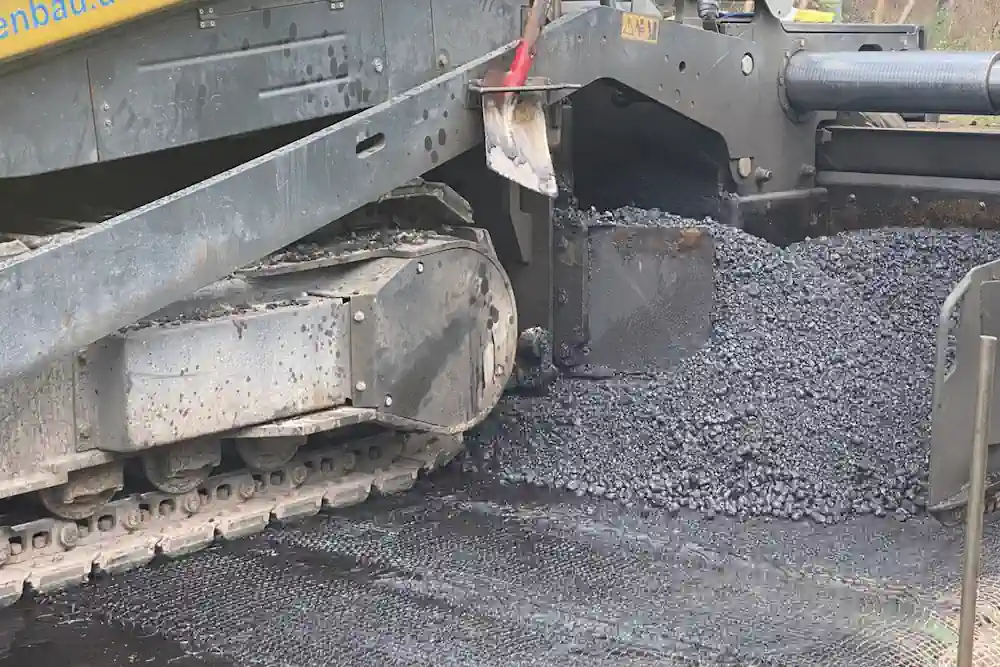 Les pavés routiers recouvrent le tissu de capteurs avec de l'asphalte.