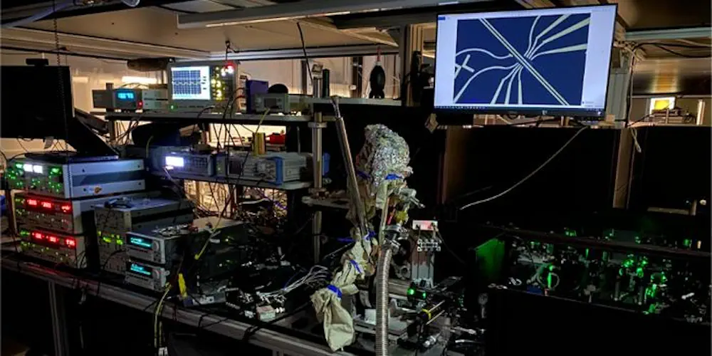 Les expériences ont utilisé des impulsions laser vertes ultrarapides focalisées dans un cryostat pour générer et détecter la lumière térahertz. Une image au microscope de l'échantillon contenu dans le cryostat est affichée sur l'écran de l'ordinateur.