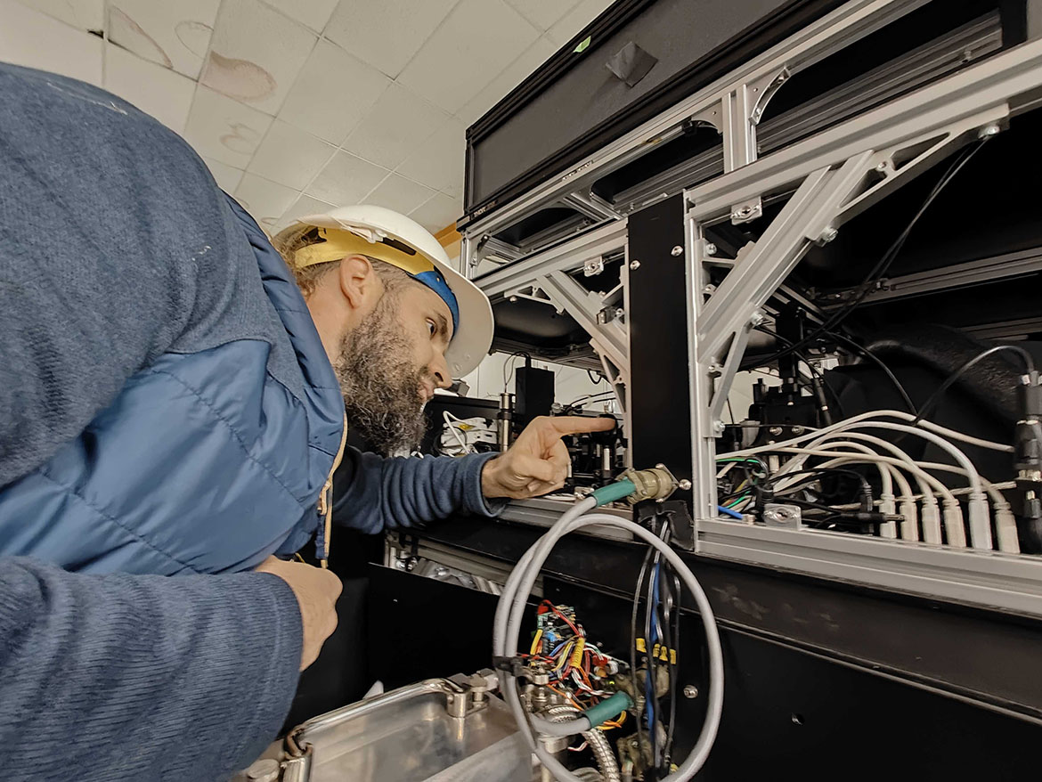 Sébastien Vievard grimpe sur l'instrument SCExAO, dans lequel la lanterne photonique est installée, pour vérifier le point d'entrée de la lumière et s'assurer du bon positionnement des éléments optiques.