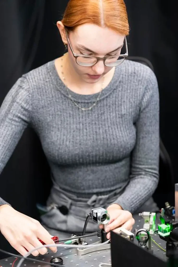 Réglage du dispositif expérimental. Andrea Stöllner ajuste avec précision l'orientation des faisceaux laser, des miroirs et des caméras sur une table anti-vibrations. © ISTA