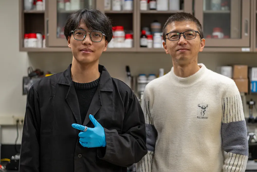 Yangbo Yuan, étudiant diplômé en sciences de l'ingénierie et en mécanique, et le professeur Huanyu « Larry » Cheng, professeur agrégé James L. Henderson, Jr. Memorial en sciences de l'ingénierie et en mécanique à la faculté d'ingénierie, posent avec leur dispositif de test de validation de concept : une bague portable dotée d'un accéléromètre miniaturisé intégré
