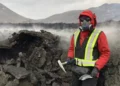 Wearing protective gear against toxic gases, Solange Duhamel stands next to a lava flow during an outing to collect samp