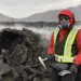 Wearing protective gear against toxic gases, Solange Duhamel stands next to a lava flow during an outing to collect samp