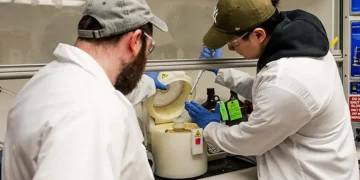 Dor Tillinger and Wonbae Lee, two researchers in the Penn State College of Engineering, prepare a glass substrate with m