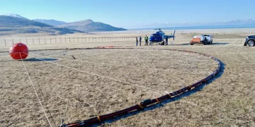 L'équipage d'un hélicoptère se prépare à transporter du matériel de prospection électromagnétique aérienne depuis une zone de rassemblement sur l'île d'Antelope, le 28 février 2025