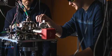 Robert Niffenegger (à gauche) et Christopher Caron au laboratoire de calcul quantique et de photonique sur ions piégés de l'UMass Amherst