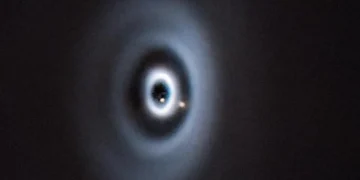 Ce à quoi aurait pu ressembler la formation de la Terre dans notre système solaire. La naissance de deux planètes (points marron clair) dans un disque protoplanétaire autour de la jeune étoile WISPIT 2