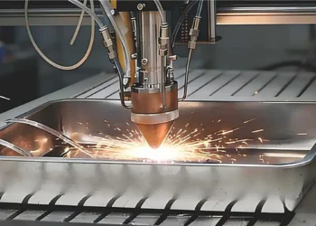 Gros plan sur un système de dépôt d'énergie dirigé par laser (LDED) servant à la fabrication d'un nouvel acier à très haute résistance conçu par IA, qui offre un équilibre exceptionnel entre résistance et ductilité ainsi qu'une excellente résistance à la corrosion, et qui ne nécessite qu'un traitement thermique en une seule étape d'une durée de 6 heures, à moindre coût.