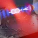 Un nanorotor en silice est piégé par une pince optique (en rouge) à l'intérieur d'un résonateur optique (en bleu). Une fois refroidi, l'alignement du rotor dans le champ de piégeage s'approche de sa limite d'incertitude quantique (cône blanc).
