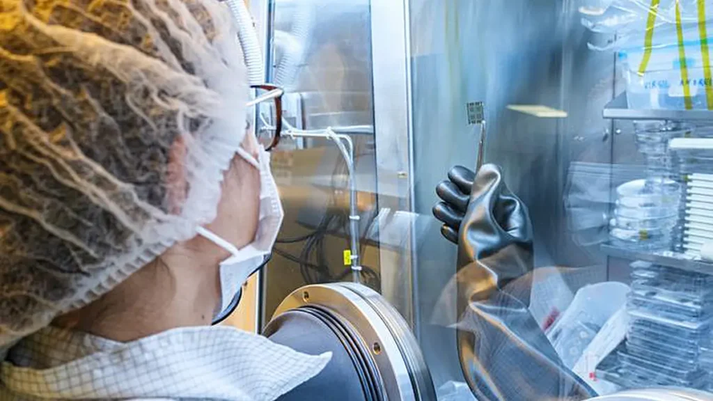 La Dr Daniela De Luca, chercheuse à l'Université de technologie de Nanyang (NTU), examine un prototype de cellule solaire en pérovskite ultra-mince dans la chambre à vide du laboratoire. (Crédit : NTU Singapour)