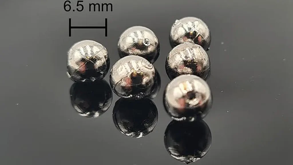 L'équipe de recherche dirigée par Ralf Busch, spécialiste des matériaux à l'université de la Sarre, étudiera à distance des alliages de verre métallique dans le cadre d'expériences menées à bord de la Station spatiale internationale (ISS). L'équipe analysera les propriétés de ces alliages à l'aide de gouttelettes chaudes en lévitation. Des billes de verre métallique comme celles illustrées ici, fabriquées à partir d’un alliage de nickel, de niobium et de soufre, se trouvent déjà à bord de l’ISS. Elles y seront fondues sans creuset et étudiées sous forme de gouttelettes en lévitation à des températures pouvant atteindre 1 700 degrés Celsius.
