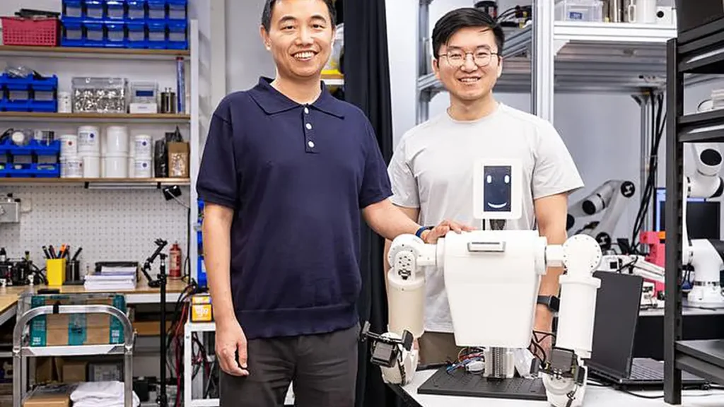 Le professeur SHEN Yajing (à gauche), auteur correspondant de l'étude, et le Dr TANG Yifeng (à droite), premier auteur de l'article, aux côtés du système EmArm. 